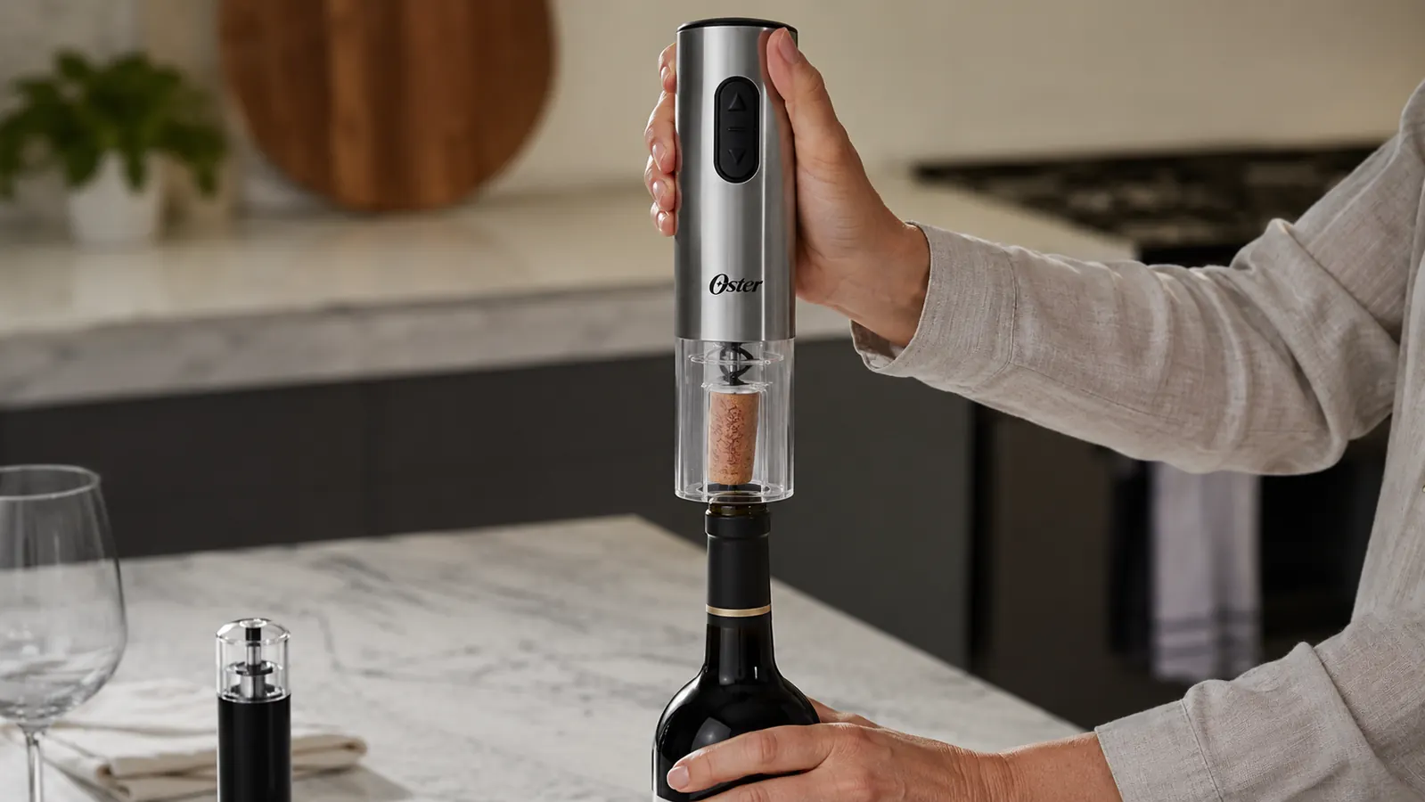 A hand holding an electric wine opener over an open bottle of wine with the cork lifted out