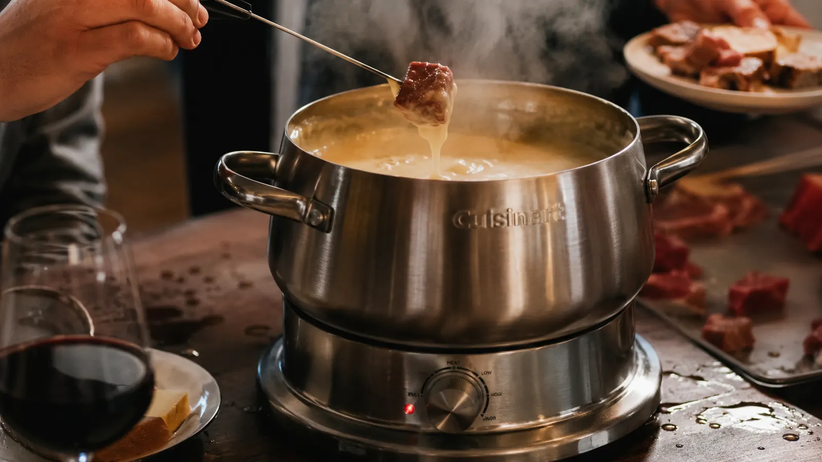 Cuisinart electric fondue pot with a light film of oil splatter on the surrounding table