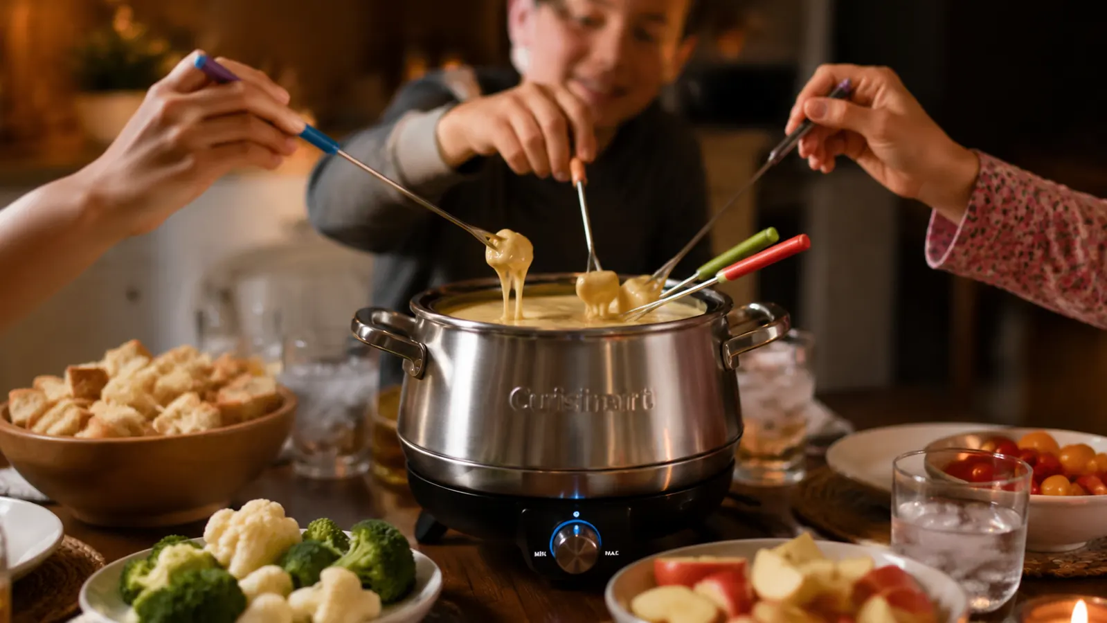 Stainless steel Cuisinart electric fondue pot set on a family dinner table with dipping forks